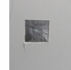 Picture shows a square hole cut out of the foamboard, covered with aluminum foil with a tiny pinhole in the middle.