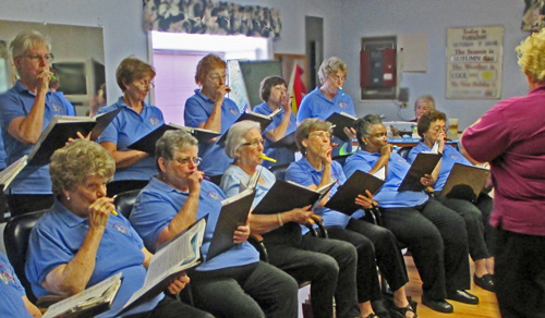 Photo shows the singers playing their kazoos.
