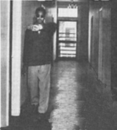 A soldier walks along a hallway, holding his arm horizontally in front of him ('upper hand and forearm technique')