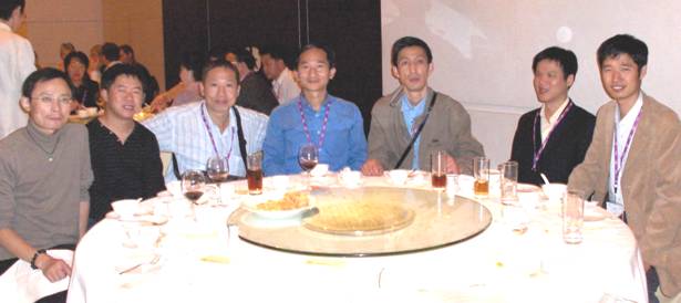Six men set at the table smiling at the camera.