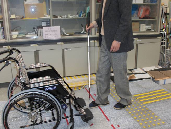 Photo shows Professor Nakamura walking past the mats toward a short slope.