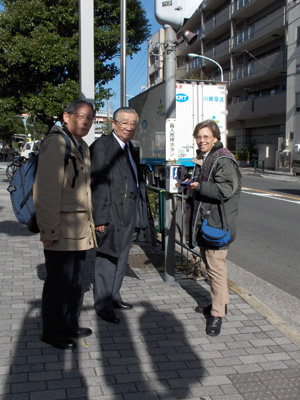 photo shows all three standing on the sidewalk and smiling at the camera.