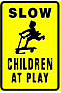 photo shows sign saying 'SLOW' on top, below it is a graphic of a child on a scooter and below that says 'CHILDREN AT PLAN'
