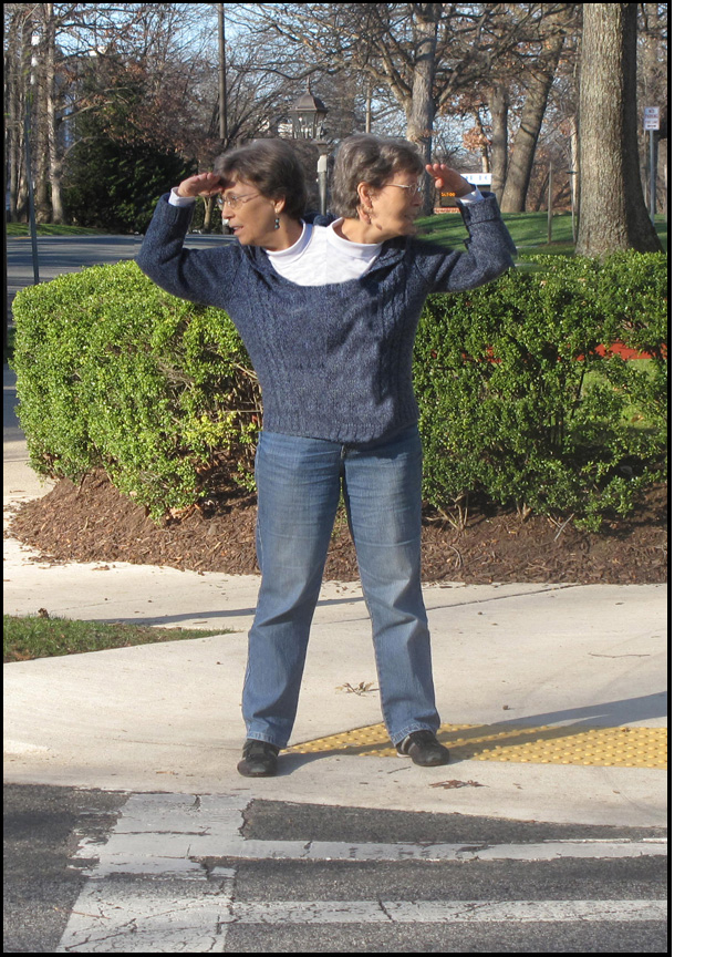 Photo shows Dona with two heads standing at a crosswalk; one head is looking to the left and the other is looking to the right.
