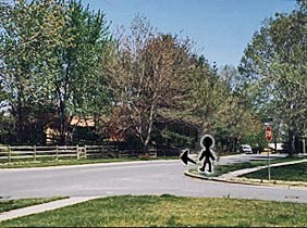 Photo shows a two-lane residential street that bends sharply and disappears less than half a block away.