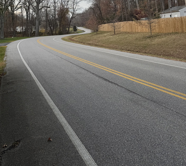 Photo shows a long, winding road that is completely empty.