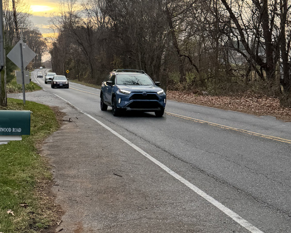 Photo shows a street with about 5 cars in the nearest lange, approaching very close together, with the closest one only about 50 feet away.