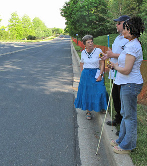 6 photos show Paul and Jomania standing at the side of a straight street with no parked cars. Dona is talking with them and pointing out cars coming from their right or left.
