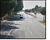 photo shows two lanes approaching from our left on one side of a street divided by a median strip.  The median strip and one of the lane-marking lines end about 50 feet away